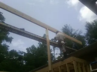 Carpenter setting a ridge beam over a new addition frame — Ice Dam Removal by Roofing Brothers in Slingerlands