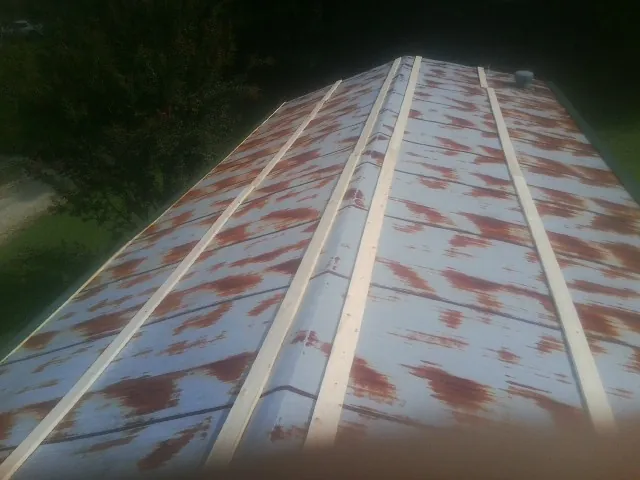 Rusted metal roof panels with new wood purlins before replacement — Storm Damage Roof Repair in Slingerlands by Roofing Brothers