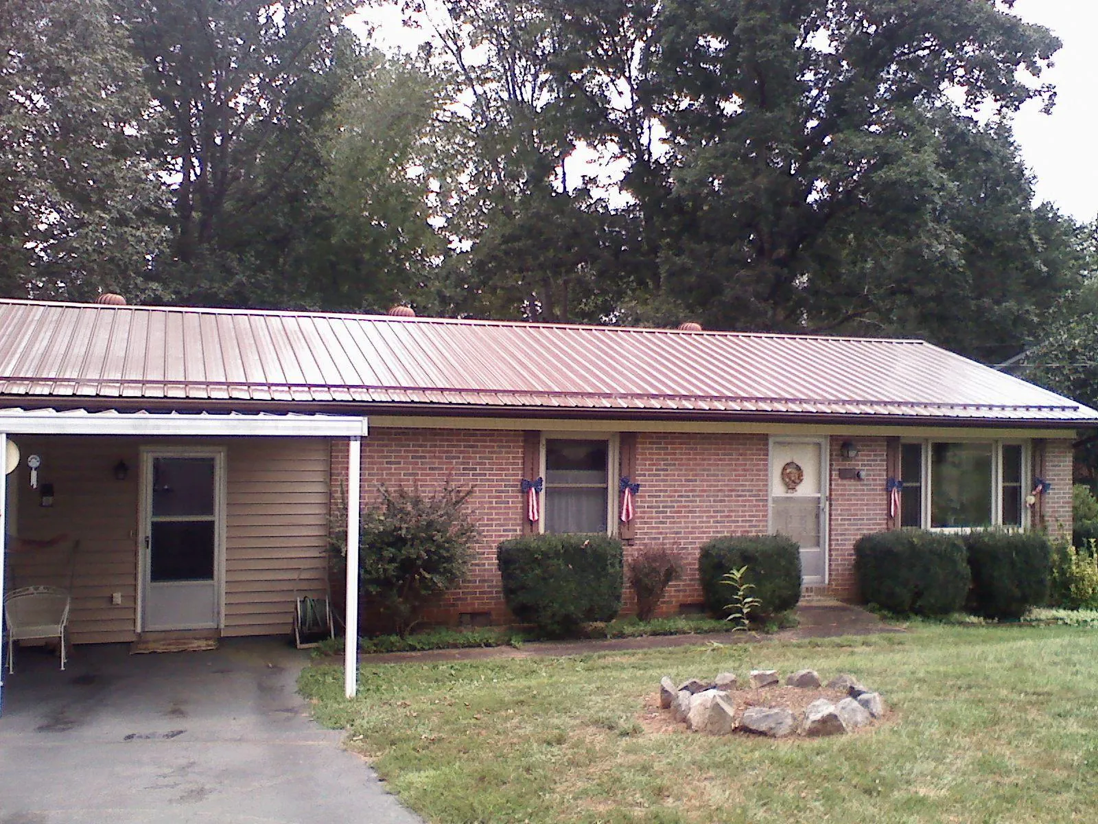 Bronze metal roof and carport on a brick ranch home — Roof Repair work by our crew in Slingerlands